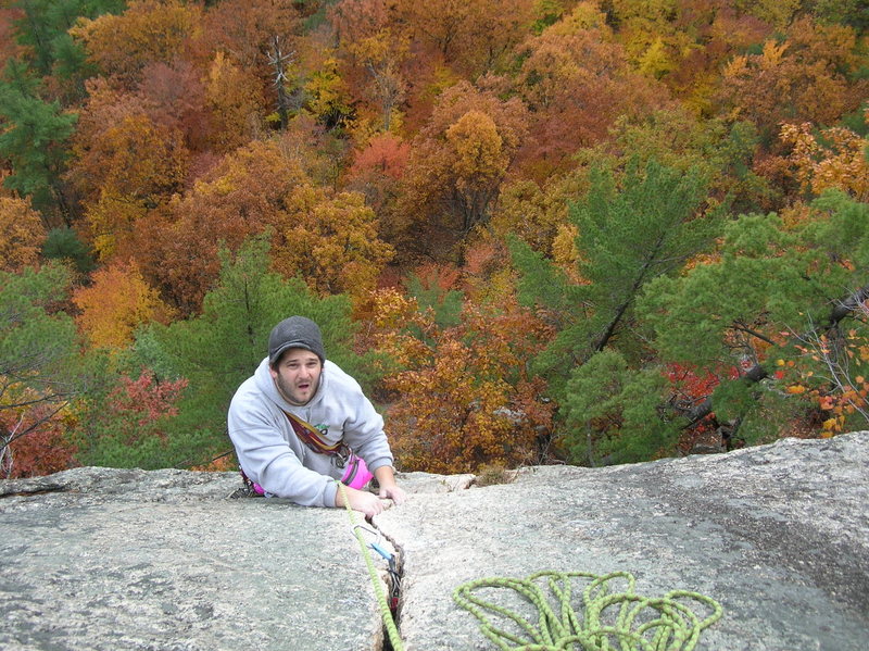 Joshua nearing the tree belay ledge atop Inferno's crack pitch.