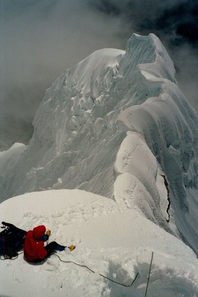 Looking back on the NW ridge of Chopicalqui. Alan Doak belaying Stefan Griebel from a butt seat anchor. Prior night's campsite was on the shoulder at the end of the ridge. <br>
<br>
"People think I'm crazy, but when I'm on a ridge with a 500' drop to my left and a 1000' drop to my right, I do what any sane person would do. I stay closer to the left side." -Jeff Lowe?