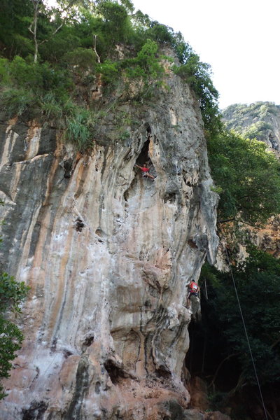 A climber at the anchor of Nuat Hin while one of guides from King Climbers works on Muai Thai.