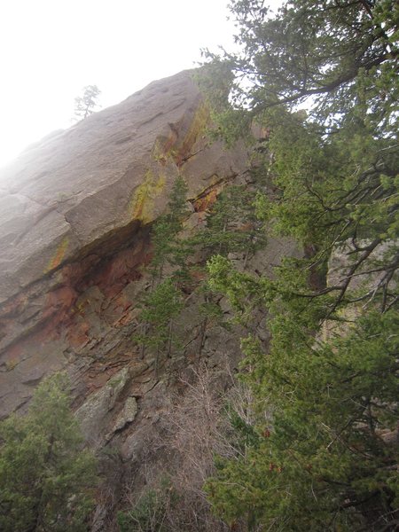 The route 'Third Eye' ascends to the right of the large overhang and up over the tress at the cliff base into the right-facing, right-leaning dihedral to the ridge on the Achean Pronouncement.