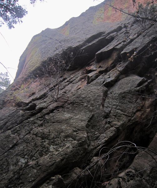 The North Buttress (5.10+, PG13) ascends the two sickle-shaped flakes low and right on the image to reach the sloping ledge, then ascends to the hand-to-tips crack through the 4-foot roof and then out diagonally left to the ridge line.