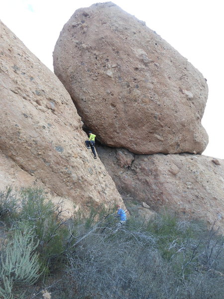 A climber working up the face below the crux of "Night Shift," with the west face of The Egg in the background.