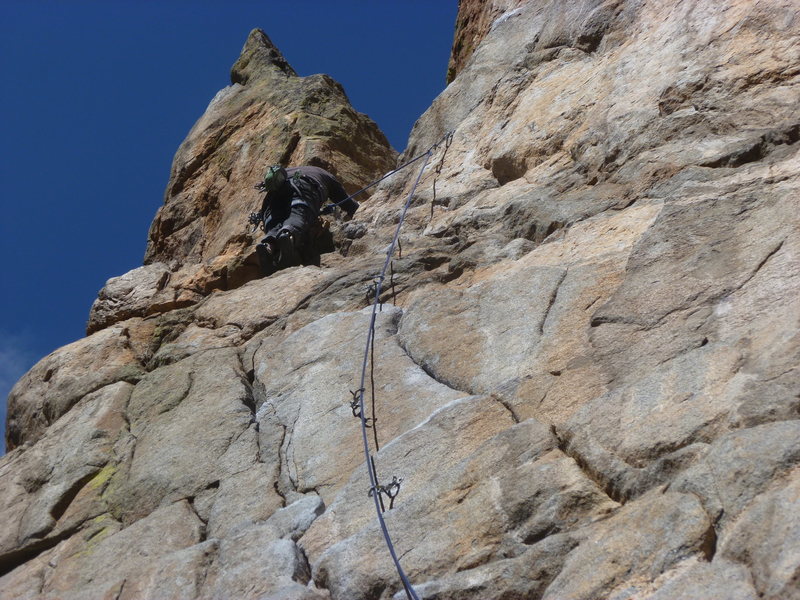 To the left of the last bolt.
