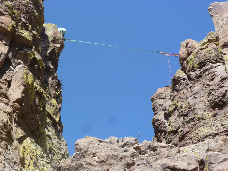 Someone set up a tyrolean (or slack line) between the pinnacle and the rock.