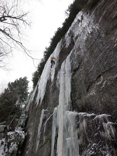 Climber on the upper curtain of Ice Storm. This photo shows how the route formed in 2013; usually one has to traverse further left to the bigger curtain.