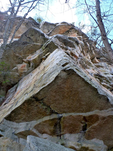 View of Disneyland from below. P1 goes left to right on the prominent face on the left, with an optional belay after the mantle. P2 goes up the corner above until the last roof, then traverses right to easy face climbing to the top.