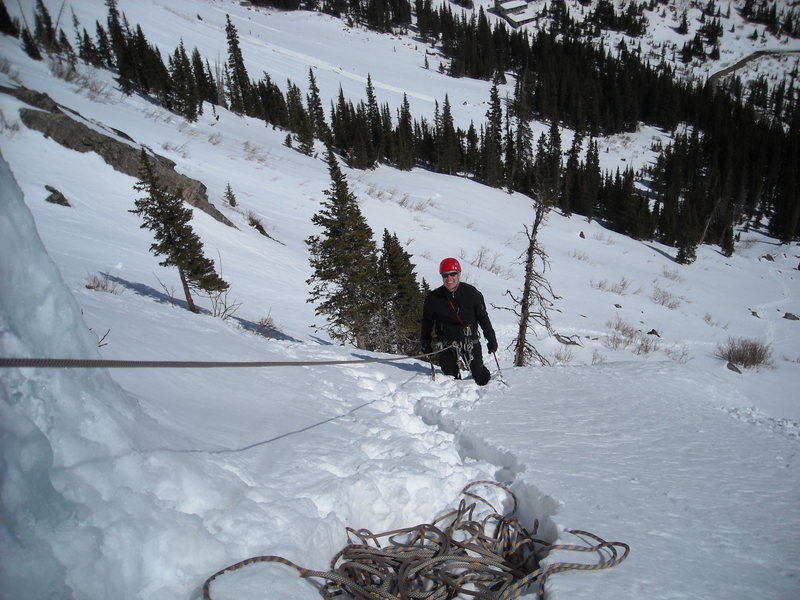 Steve Duff atop 1st pitch of scottish gully. Observe slide zones above the band of trees!