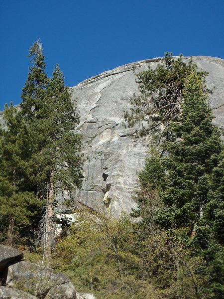 From the road. The first pitch is behind the trees to the left and the upper two pitches follow the corner in the top center of the picture.