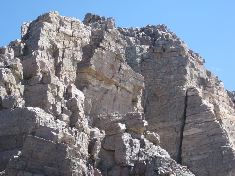 The Direct South Ridge climbs through this exposed section of easy 5th class. Someone has placed a fixed rope here to aid in ascent/descent. As seen in this photo, the wind can render it useless.