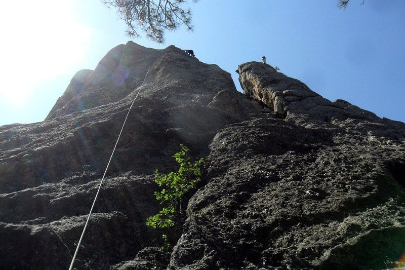 Brenda works the Shark's Breath arete while a climber rappels from Shipyard Rock next door.