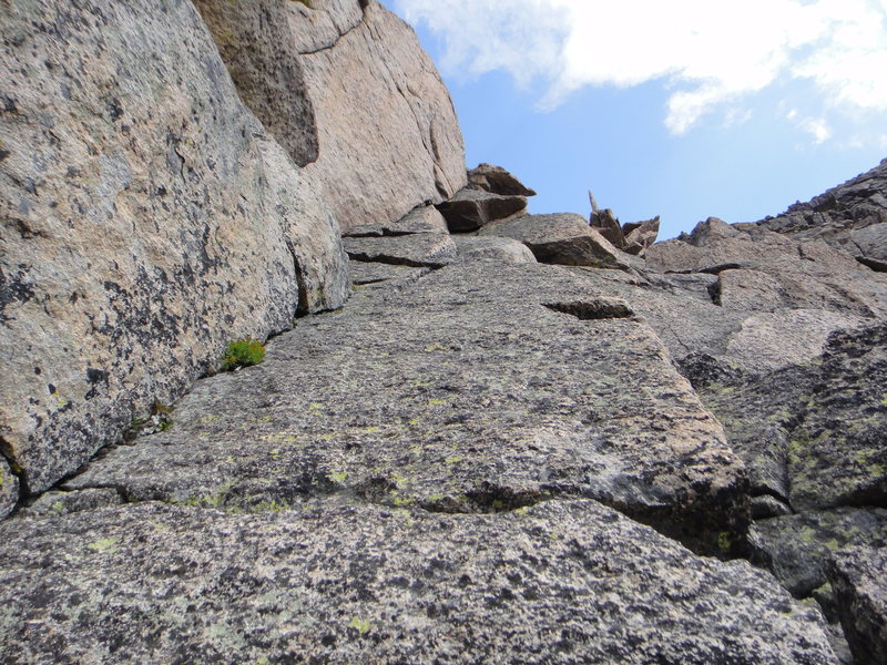 Another right-facing dihedral just right of the ridge crest. <br>
The route continues past the right side of that blade on the skyline.