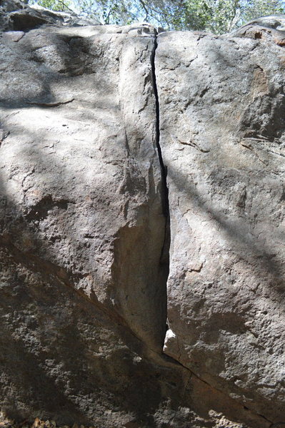 La Petite Fissure (~V0). Start low on the left-facing sidepull and avoid all holds but the crack.