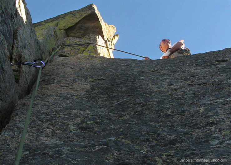 The dicey step-around to a spacious belay.
