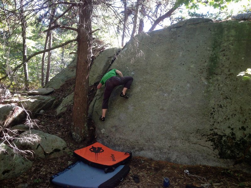 Ryan on Super Clap (V3-V4). Sticky Rubber Discharge (V3-V4) climbs the central section immediately to the right.