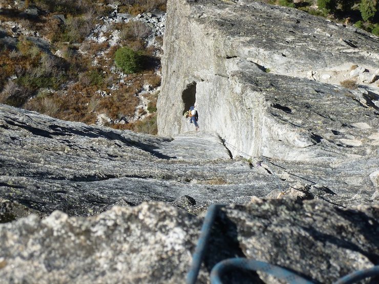 Griffiths navigating the airy 5.7 traverse back into the corner of the book, an old and twisted piton offers minor protection.
