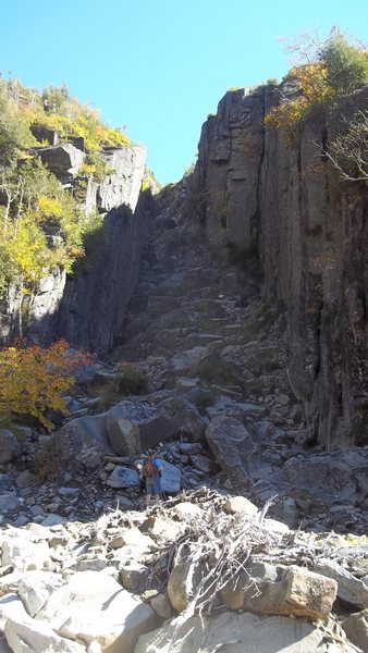 Looking up from base, merely a simple scramble at the start. "Enlarge" to see climber in shorts mid center for scale.
<br>
There must be excellent climbing opportunities on either side of the dike although the routes looked pretty vertical.