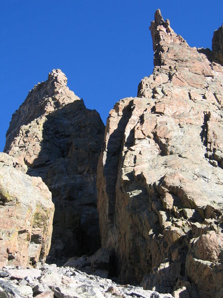 Similar photo as previous, exposed for sunlit rock. Shows the base of the route, as well as the prominent dihedral of the Davis-Fowler. Sharkstooth on the left, Petit Grepon on the right.