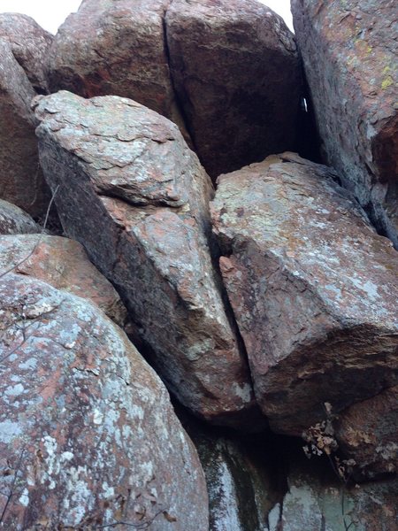 The route goes through the crack in the large boulder.