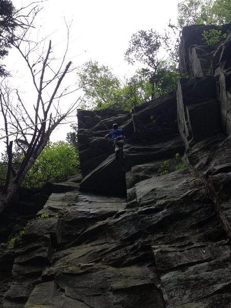 Cleaning the fin on The Fin. The bolts to the left in this photo are for this route. To the right is the bolt line for Wall of Voodoo, which goes to the right on the left-facing wall, then shares the last two bolts with The Fin. The bolt high in the photo and to the right is on Climb With a View.