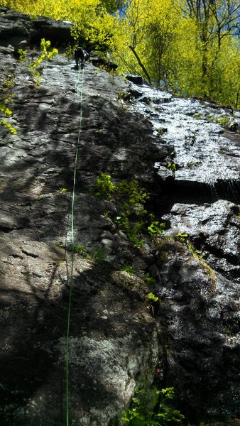 Matt rigging a rappel on Curly for President. Bolts are visible to the left of the rope.