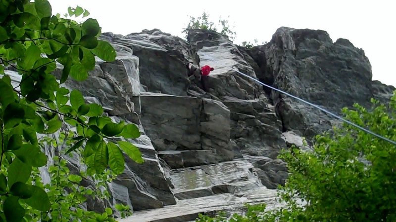 Climber wrapping up at the top of Nutsweat, just past the final roof move.