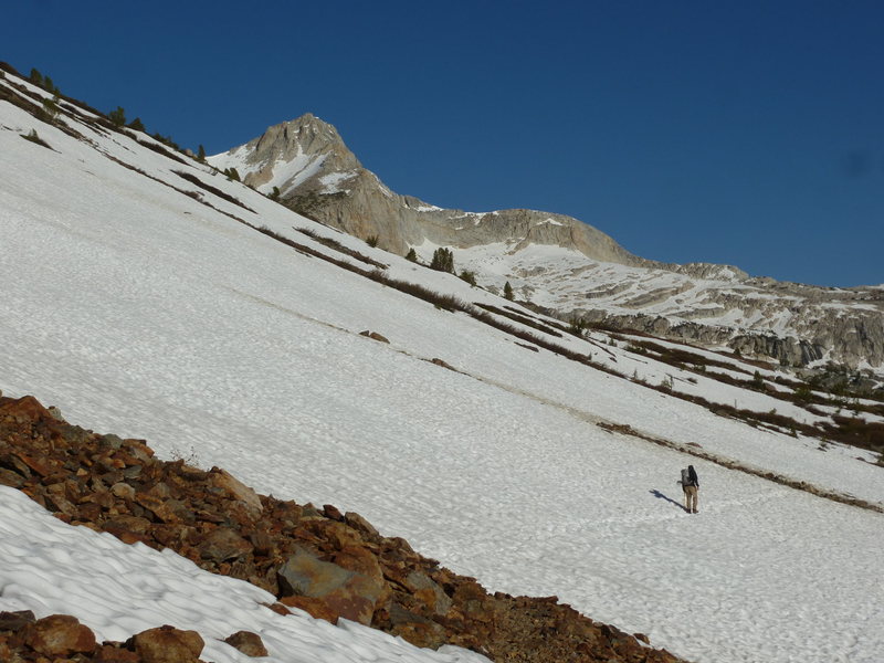 Jeff on west snowfields on shoreline of Saddlebag Lake, with North Peak finally coming into view.