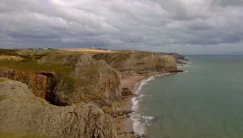 Looking East from Fall Bay. Typical Gower scenery: sandy beaches, limestone cliffs and a cloudy sky.