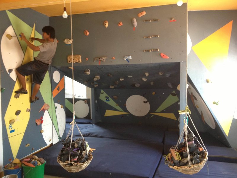 An I.O. staff member and their newly painted wall. Guests are welcome to set their own routes and take lessons in and outdoors.