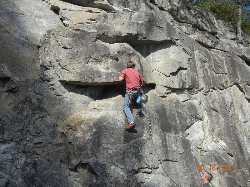 Standing on the micro-ledge and clipping the second bolt. When climbing this way, you come up directly under the second bolt.
