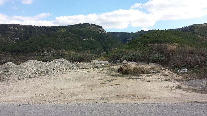 This is what the small parking area looks like from the road SP5. The crag is the rock face down below.