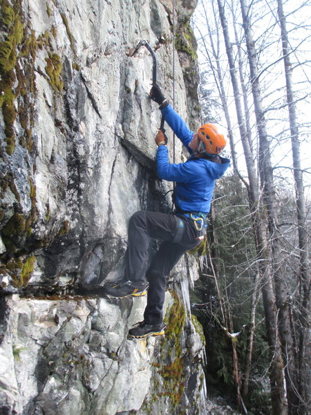 A climber moving through the thin top section of the climb.