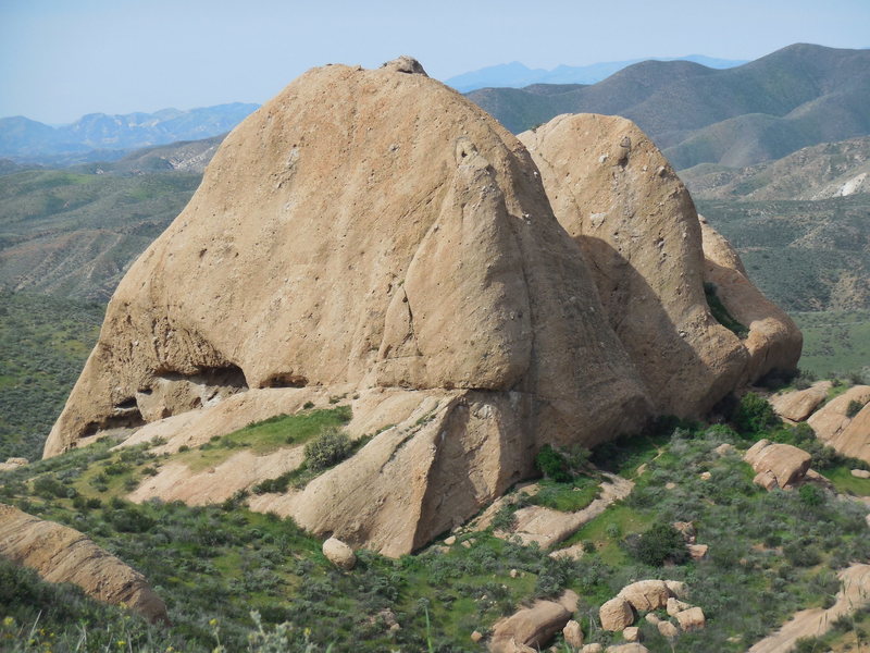 The east face of the Elephant's Head surrounded by verdant green hills.