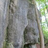 Looking along the cliff to the north from below Team Motivation.  Kama Sutra 218 is shown in profile climbing the bulgey prow at center, and Geht is facing the camera just to the right of center.