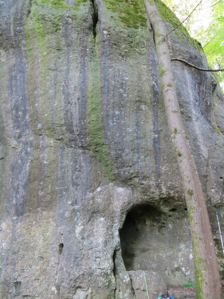 KZzA climbs the line of tiny pockets directly above the left side of the small cave (and just right of the green slime oozing out of the wide crack in the top of the photo).