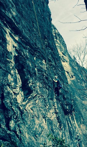 This is Mary finishing the alternate start. The original start is climbers left in the white swirling rock. The first bolt is several body lengths above the climbers head.