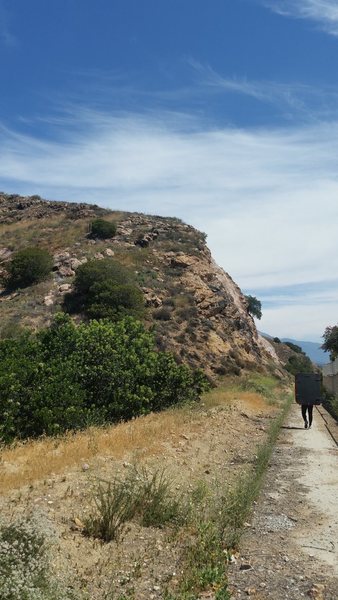 Walking down the cement path behind the houses toward the boulders.