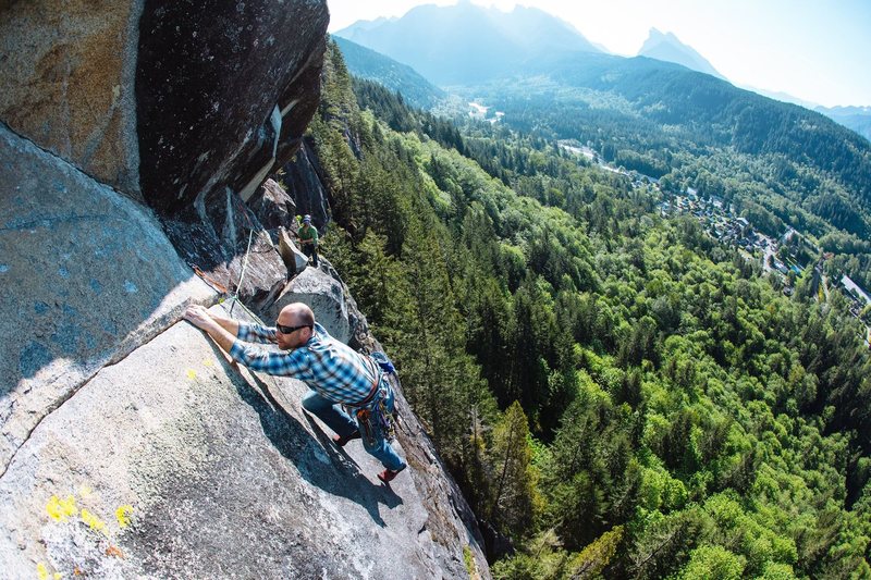 Derek Pearson, pitch 4 of Little Fire on Duck Wall. Mt. Baring and the town of Index in the background. (Wide-angle lens has distorted the angles, making wall look less steep.) Photo by Matthew Van Biene.