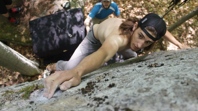 Rob pulling the crux hold, preparing to throw for the top.