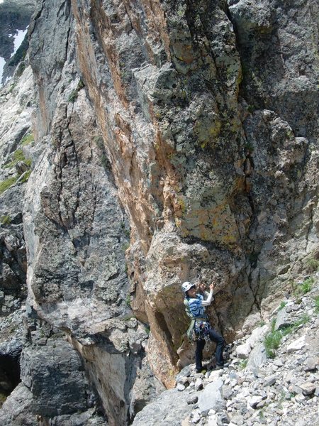 Jen pointing out where the last very hard to spot rap anchors are. Down and to the right of the slinged chockstone.