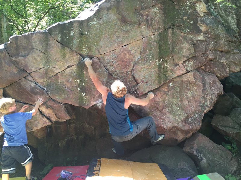 Middle of Boulder start on razor sharp right crimp and left hand thumb pinch. Make big move to incut left find your feet one more throw and mantle the top.