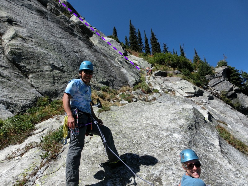 Topping out on Have a Line to the "start ledge" for most routes. The two climbers racking up in the background are at the base of the Harem route.