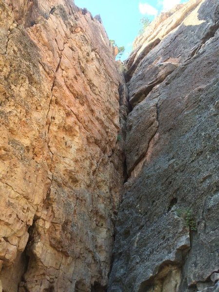 Peking on the right face of the dihedral. Route meanders over on to the blunt arete. Loose rocks and spiky weeds.