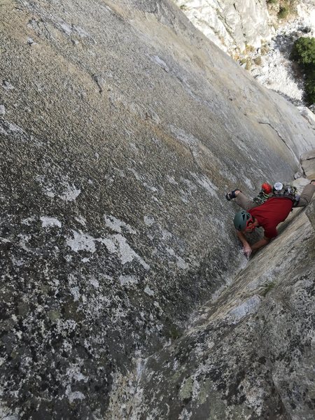 Kyle places a brassy before the crux on pitch 2.