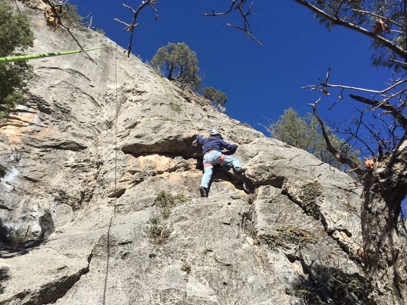 Climbing through the roof at the lower crux of The Harvey.