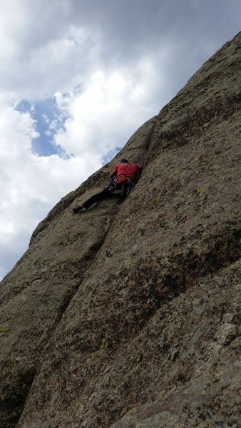 Leading the flared handcrack near the top of pitch one.