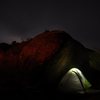 Campsite under boulder at night.
