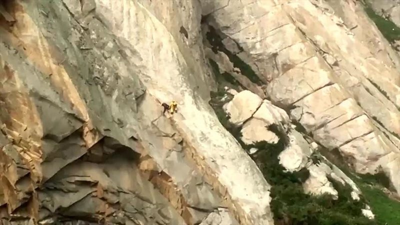 snipped from climbing mag Hot Flashes:<br>
<br>
"Visitors to the cliff had eyed the obvious line formed by the dark and light stone for years, but contented themselves with the easier roof to the left. Banksittation changed all that (which some say is just a fancy name for combining known techniques: full body scumming with neoprene suit, facing out on outside corners, and elbow jams). "<br>
<br>
Shown is Banks on the FA with his camera crew in yellow. (photo credit: Tom Evans)