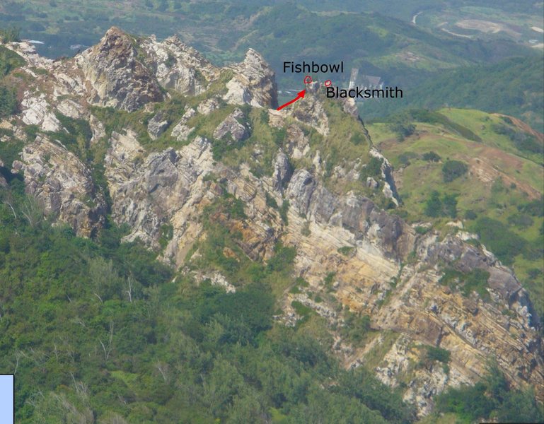The south face of Sleeping Giant Ridge, which is an area near Barclay's Park in Barbados and is not far from Bathsheba. There are many different types of sandstone and ironstone here. As a rule of thumb, the darker rocks in this photo are solid, while the lighter rocks will break apart easily. This photo was taken from google maps.