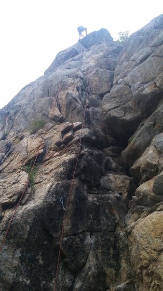 Ben cleaning the route. You can see the climb starts on the black left face. To get to the second & third bolt, you can try to climb the face or use the crack. Both very enjoyable!