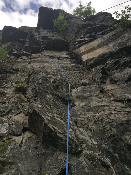 First ascensionist Sam testing the upper roof. The start is to the right of where I am belaying.